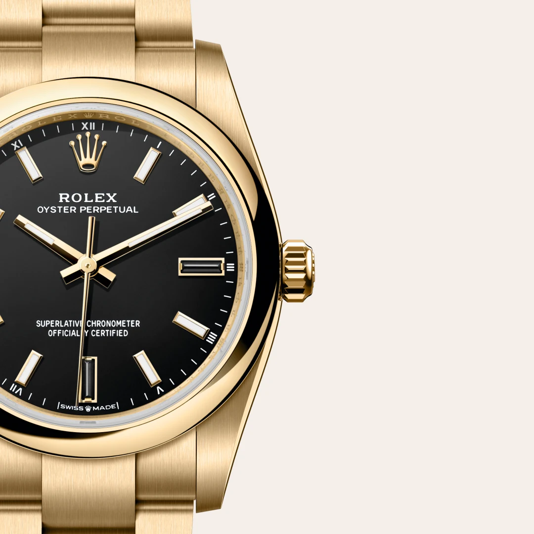 Close-up of a gold Rolex Oyster Perpetual watch with a black dial, gold hour markers, and brushed gold bracelet visible on the left. | Brela