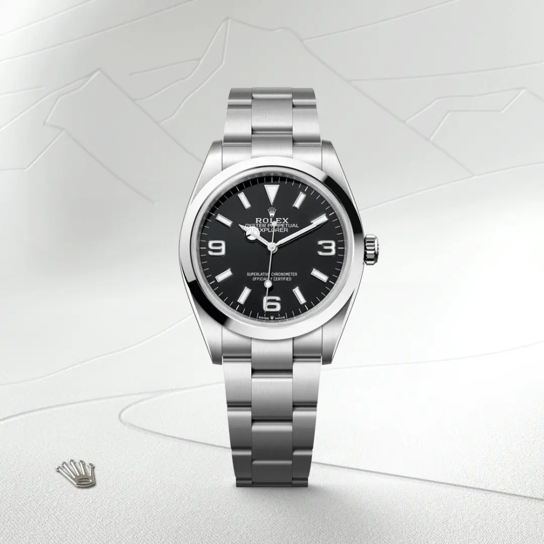 m124270-0001-slide1 | Brela Rolex Oyster Perpetual Explorer watch with black dial and stainless steel bracelet on a light textured background. | Brela