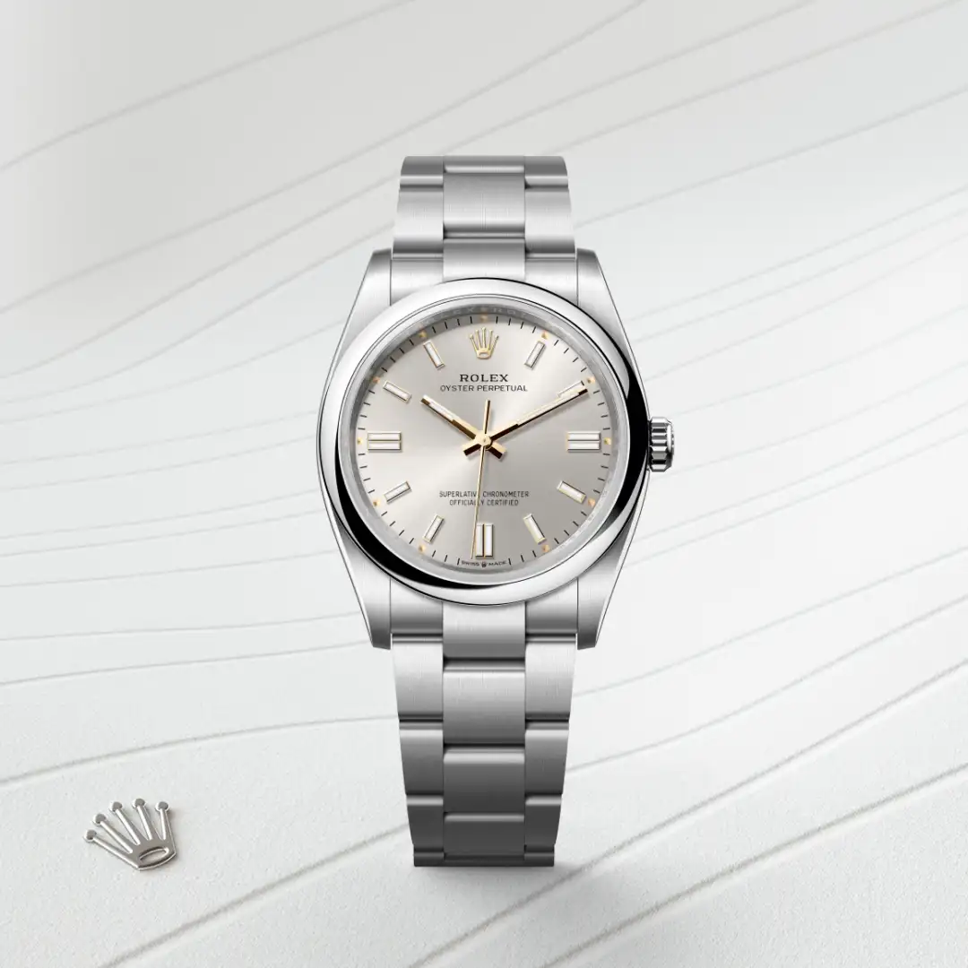 m126000-0001-slide1 | Brela Rolex Oyster Perpetual stainless steel watch with silver dial and gold accents on bracelet and crown logo visible beside the watch. | Brela