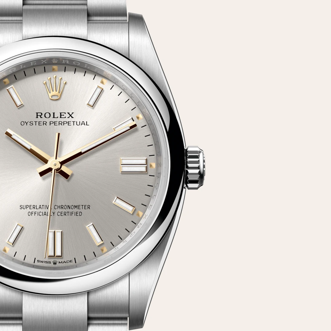 m126000-0001-slide3 | Brela Close-up of a silver Rolex Oyster Perpetual wristwatch with gold hands and markers, stainless steel bracelet, and a polished bezel. The dial reads ROLEX OYSTER PERPETUAL. | Brela