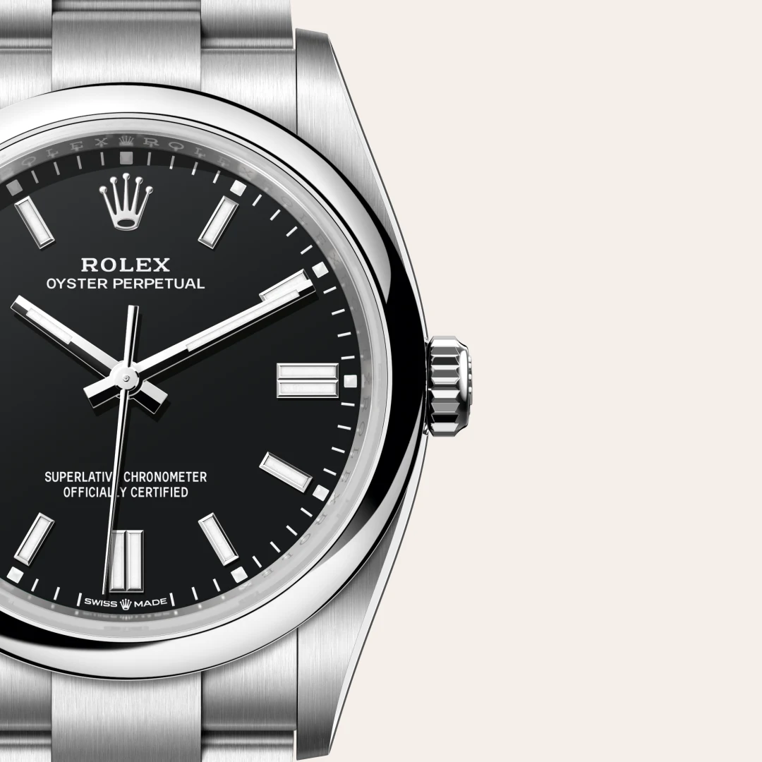 m126000-0014-slide3 | Brela Close-up of a Rolex Oyster Perpetual watch with black dial, silver markers, and stainless steel bracelet/cixed bezel edge visible to the left. | Brela
