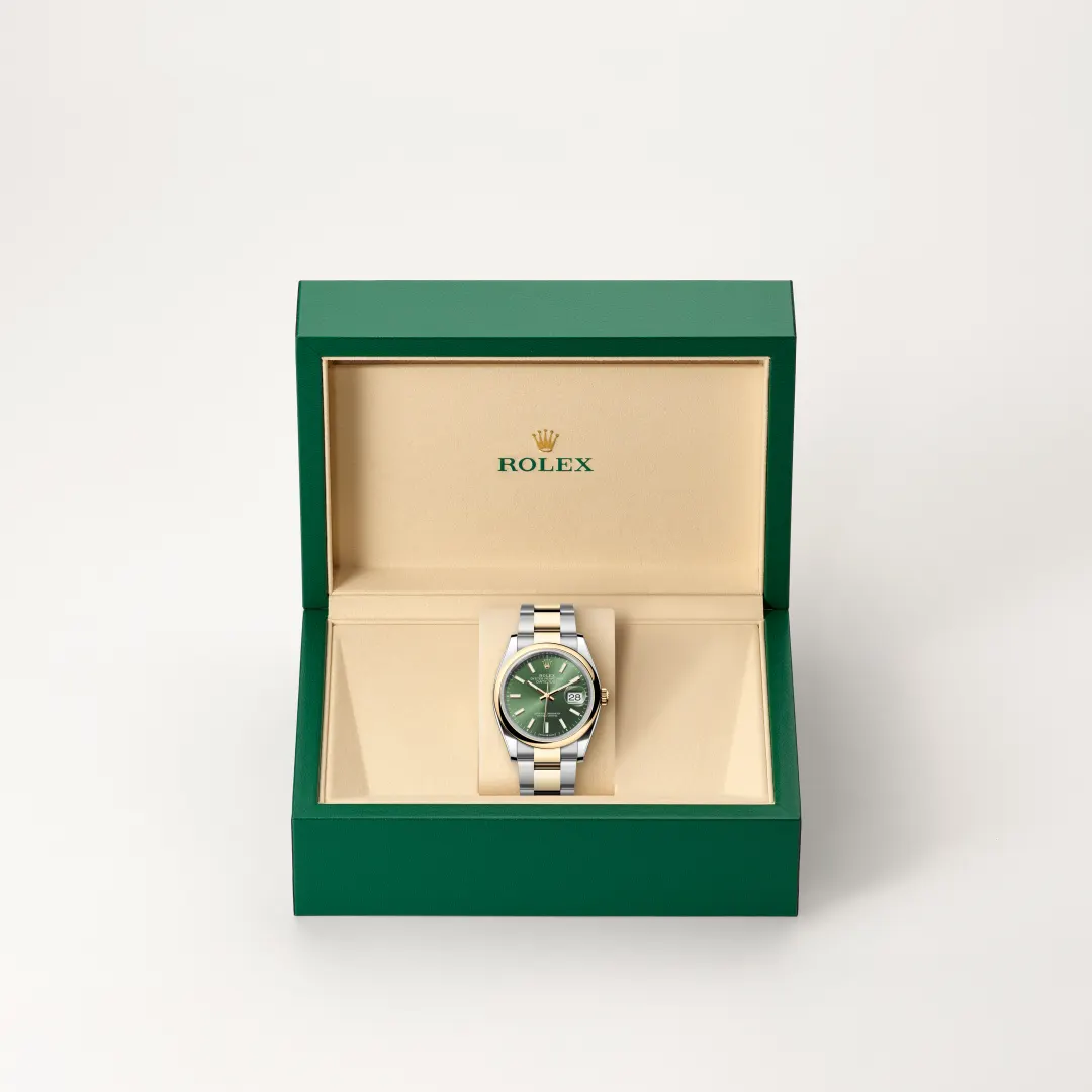 Open green Rolex box revealing a two-tone stainless steel watch with a green dial and date window. | Brela