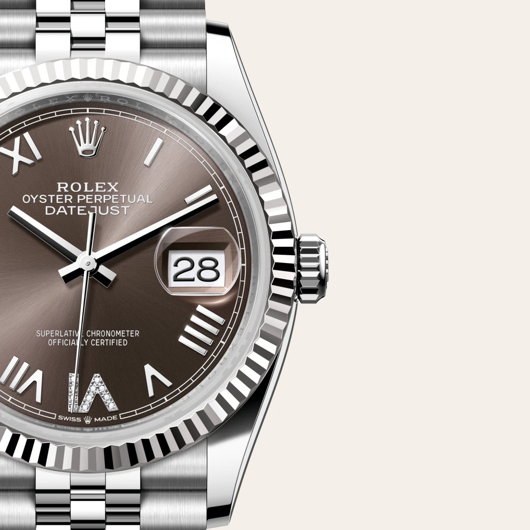 Close-up of a stainless steel Rolex Datejust watch with a brown dial, date window showing 28, fluted bezel, and brushed bracelet. | Brela
