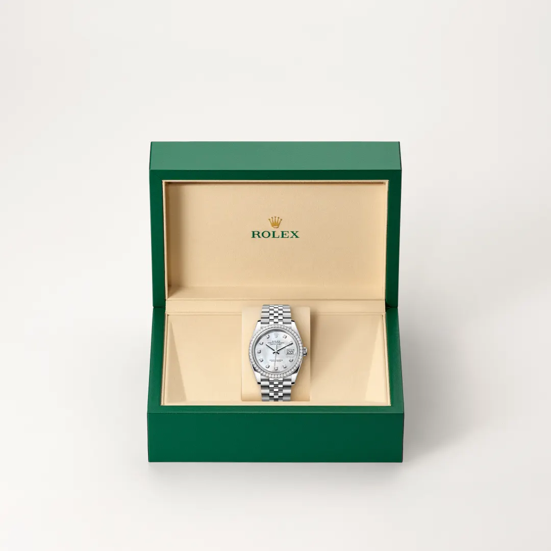 m126284rbr-0011-slide2 | Brela Green Rolex presentation box opened to reveal a silver Rolex watch on a beige display cushion. | Brela