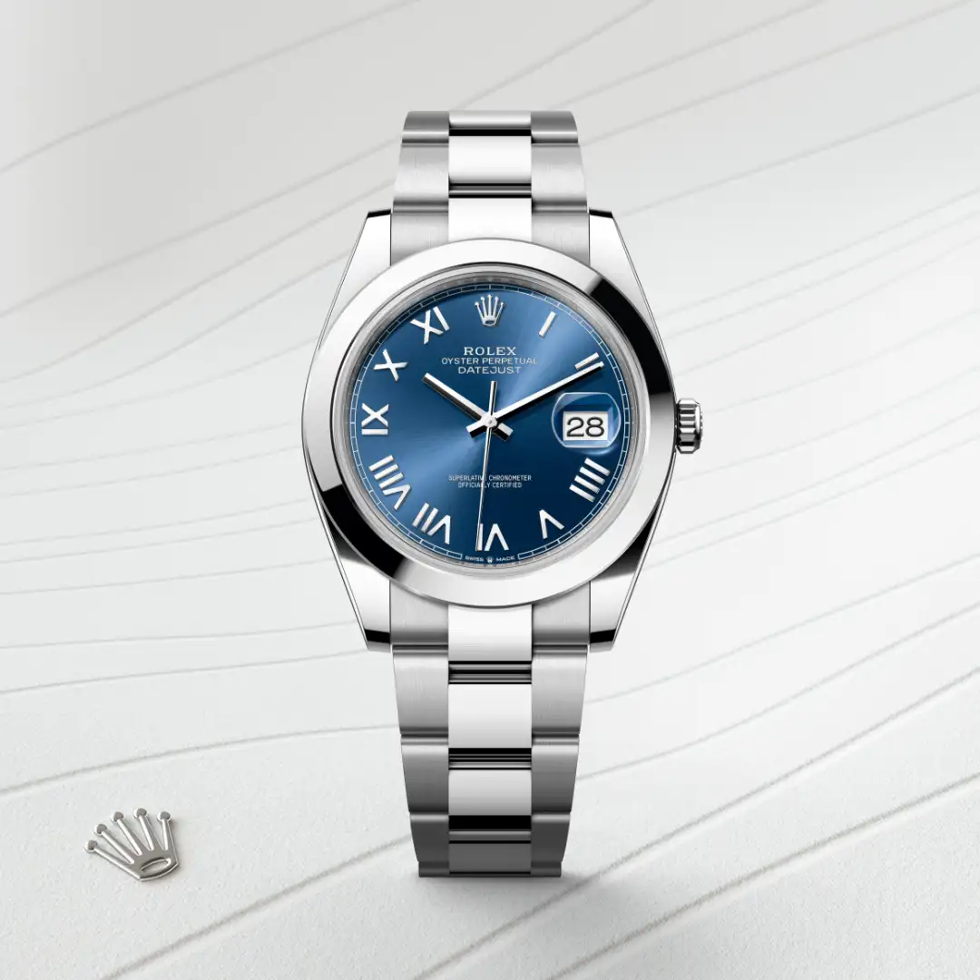 Rolex Oyster Perpetual Datejust wristwatch with a blue dial, Roman numeral hour markers, and a stainless steel bracelet showing the date at 3 o'clock. | Brela