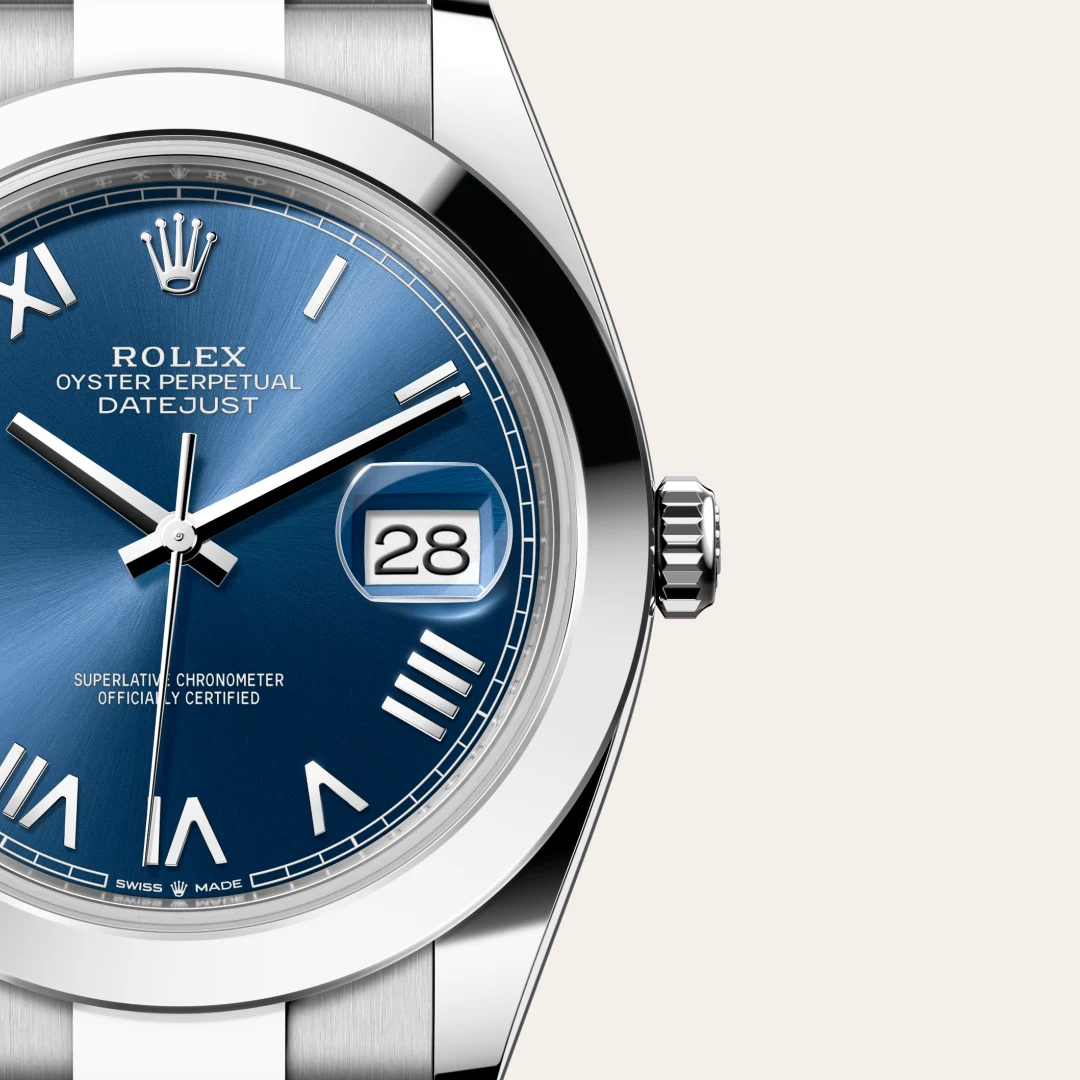 Close-up of a blue Rolex Datejust watch with a date window showing 28 and a silver bezel. | Brela
