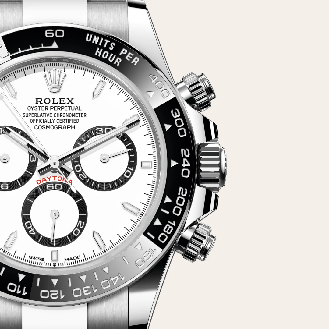 m126500ln-0001-slide3 | Brela Close-up of a Rolex Oyster Perpetual Cosmograph Daytona watch with a white dial, black subdials, and tachymeter bezel on a light background | Brela
