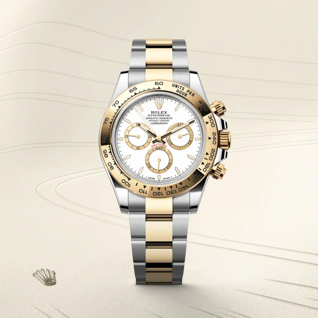 Two-tone Rolex Daytona wristwatch with a white dial, gold bezel, and silver-and-gold bracelet on a light background.
