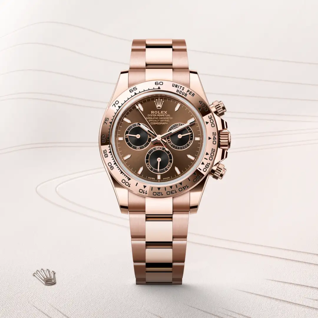 Rose gold Rolex Daytona wristwatch with brown dial and three subdials on a metal bracelet, angled to show the side buttons.