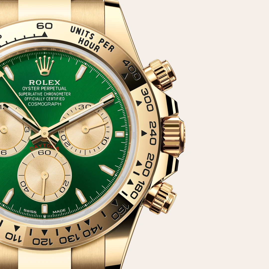 m126508-0008-slide3 | Brela Close-up of a gold Rolex watch with a green dial, three subdials, and a tachymeter bezel. | Brela