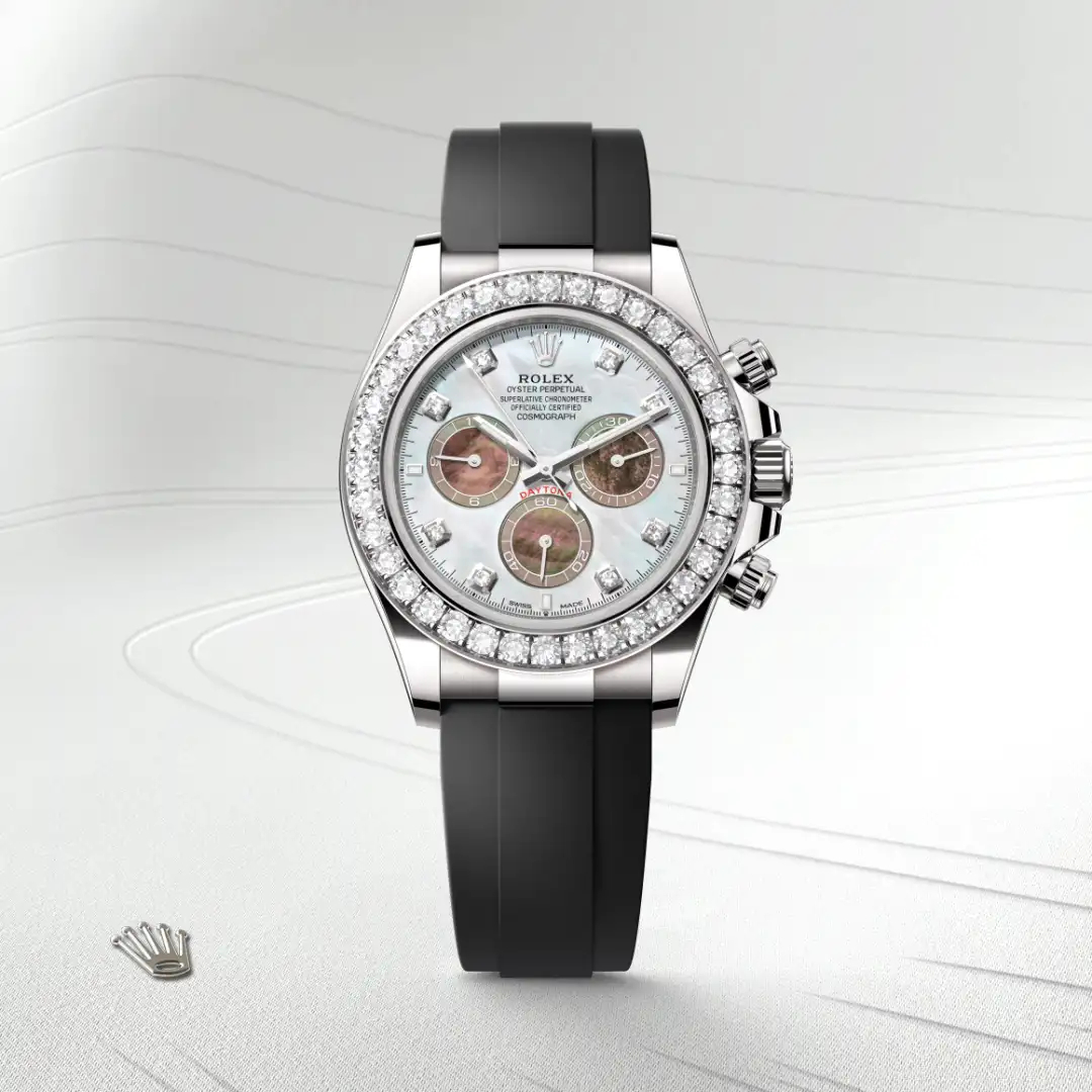 m126589rbr-0001-slide1 | Brela Rolex Oyster Perpetual Cosmograph Daytona with a diamond-studded bezel, mother-of-pearl dial, and black rubber strap on a light background. | Brela