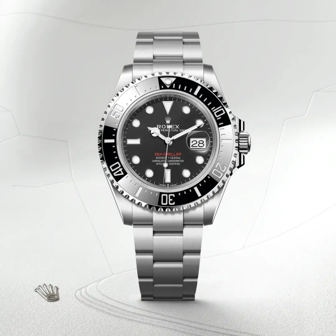 m126600-0002-slide1 | Brela Rolex Sea-Dweller watch with black bezel, stainless steel bracelet, and date window magnifier (Cyclops) on a light background | Brela