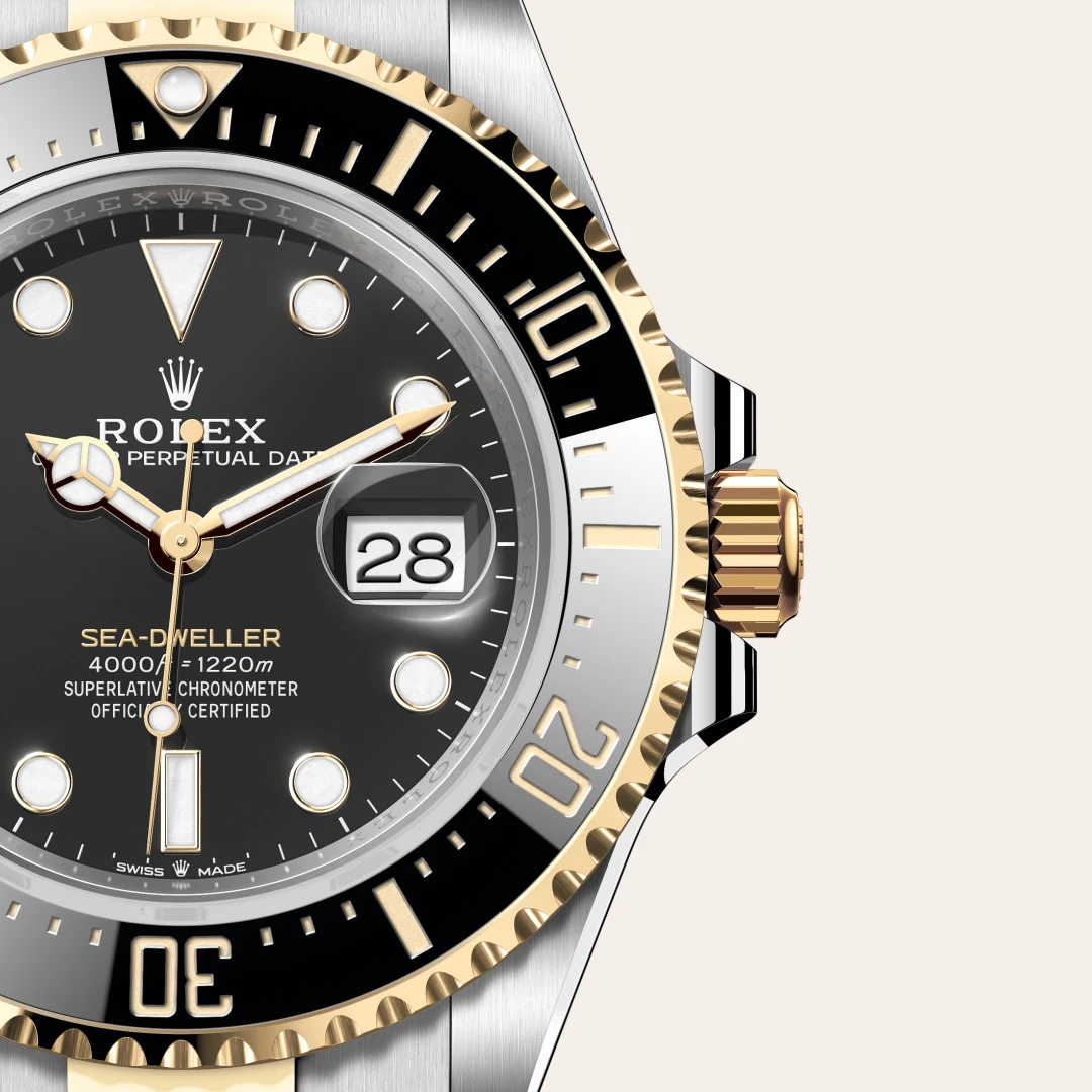 m126603-0001-slide3 | Brela Close-up of a two-tone Rolex Sea-Dweller watch with a black dial, gold bezel, date window at 3, and a two-tone bracelet. | Brela