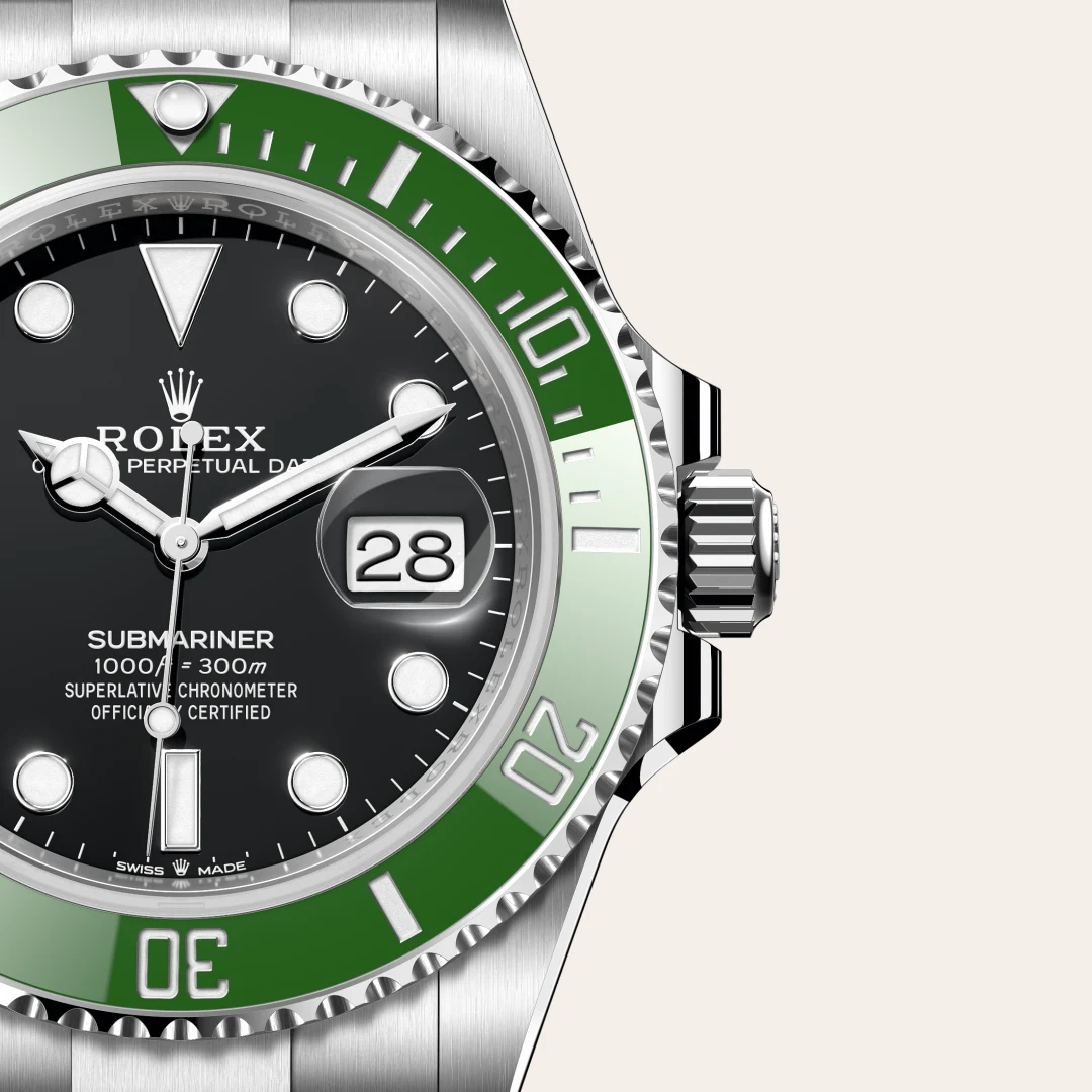 m126610lv-0002-slide3 | Brela Close-up of a Rolex Submariner watch showing a green bezel, black dial, date window at 3 o'clock, and stainless steel case. | Brela