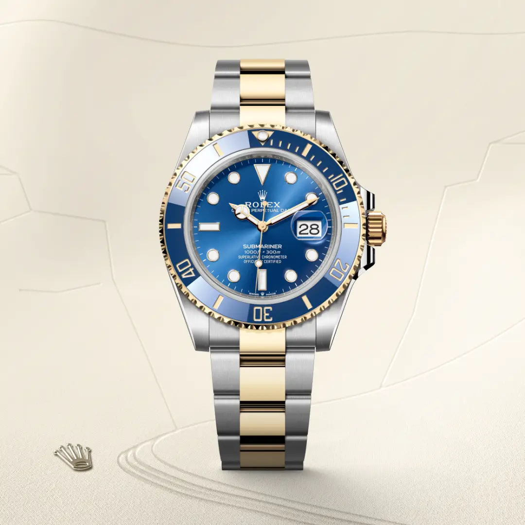 m126613lb-0002-slide1 | Brela Rolex Submariner two-tone watch with blue dial, gold bezel, and date window, shown upright on a beige background. | Brela
