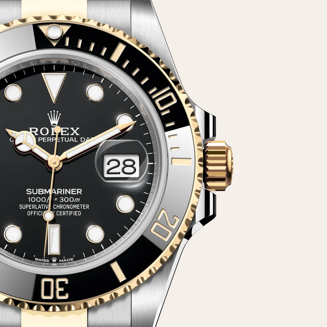 m126613ln-0002-slide3 | Brela Close-up of a two-tone Rolex Submariner watch with a black dial, gold bezel, date window showing 28, and silver and gold bracelet. | Brela