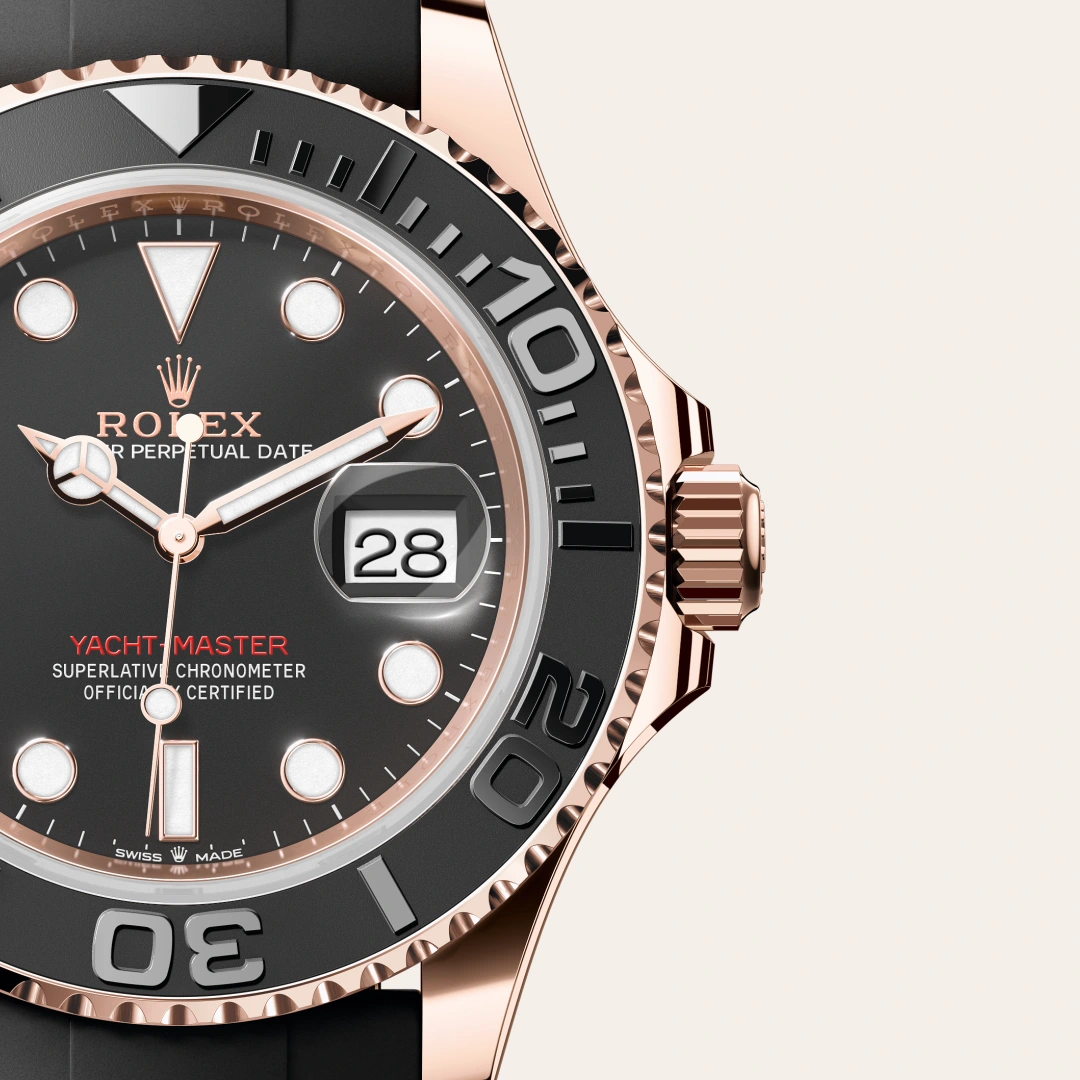 m126655-0002-slide3 | Brela Close-up of a Rolex Yacht-Master watch with a rose-gold case, black bezel, and date window at 3 o'clock. | Brela