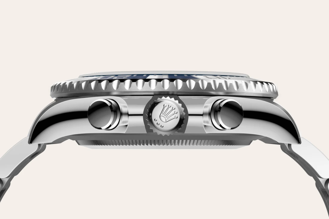 Close-up side view of a stainless steel wristwatch showing the crown and two pushers on a polished case.