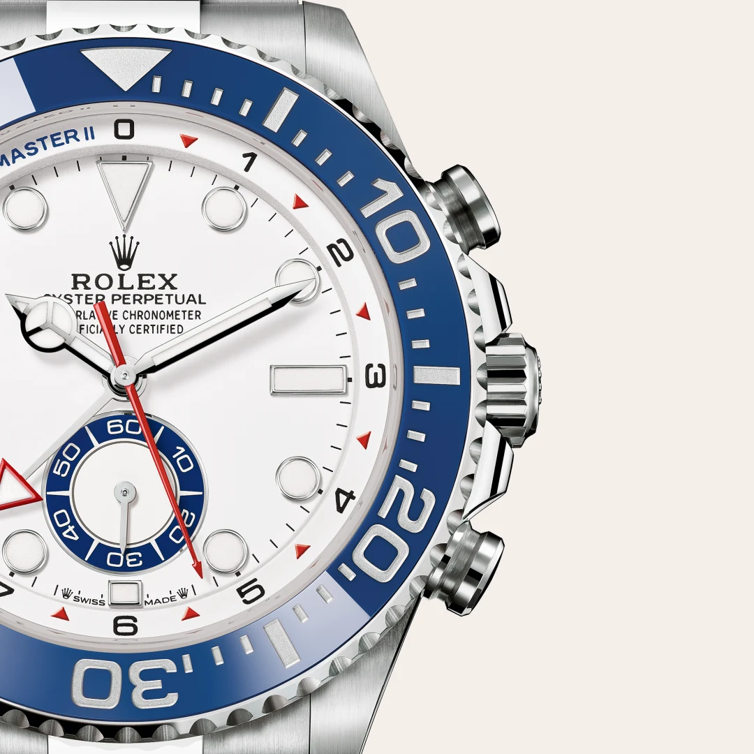 Close-up of a Rolex Oyster Perpetual watch with a white dial, blue bezel, and silver case; red second hand visible.