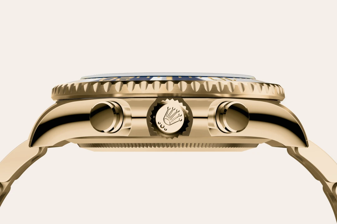 Close-up of a gold Rolex wristwatch side, showing the crown with Rolex logo and two chronograph pushers.