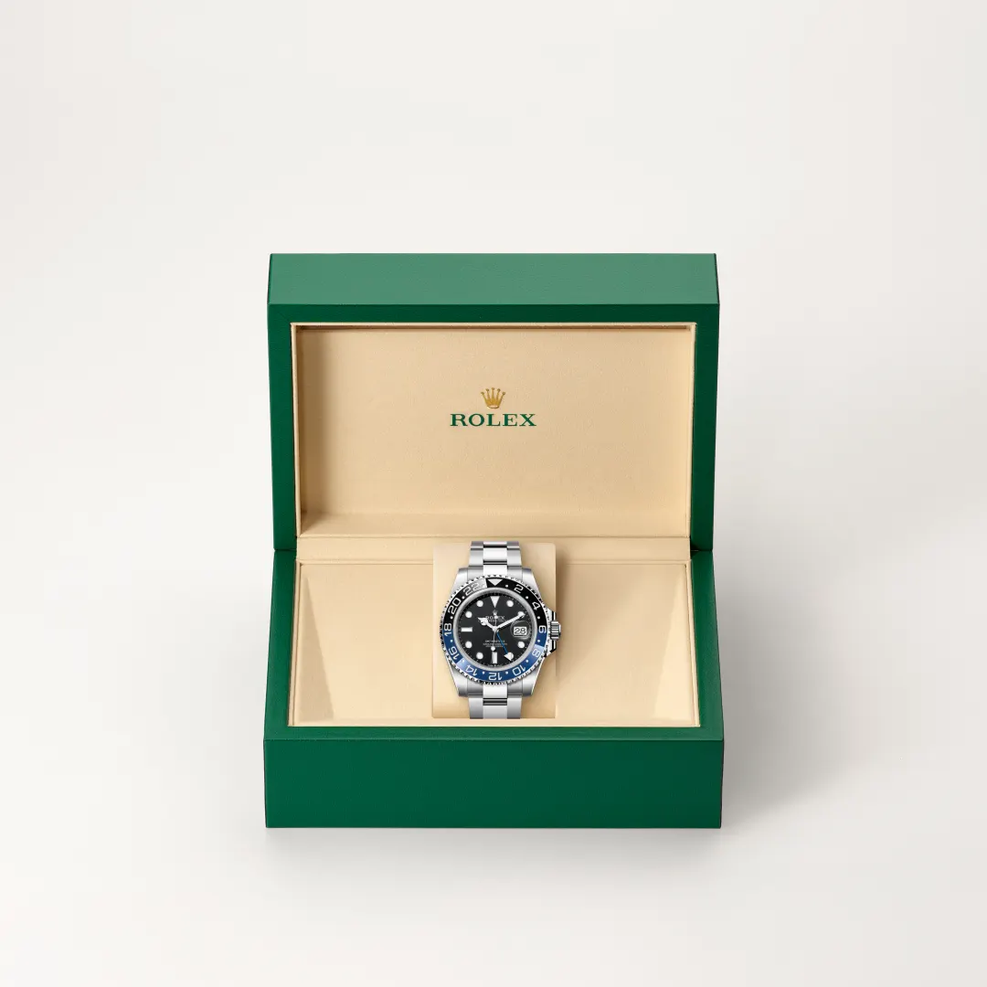 m126710blnr-0003-slide2 | Brela Rolex watch in an open green box with beige interior, stainless steel band and black dial on display stand | Brela