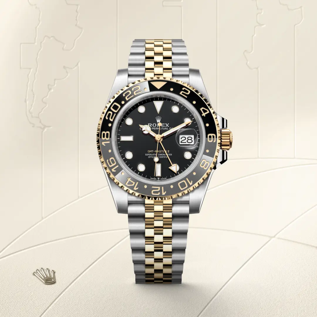 m126713grnr-0001-slide1 | Brela Rolex GMT-Master II watch with black dial and two-tone gold-and-steel bracelet, date display at 3 o'clock, gold bezel numbers visible in a neutral backdrop. | Brela