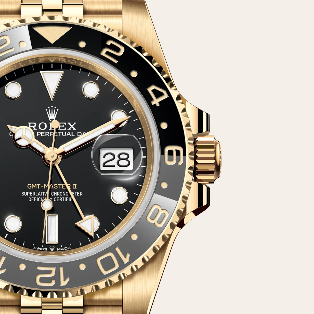 Close-up of a gold Rolex GMT-Master II watch with a black dial, gold bezel, and a magnified date window at 3 o'clock. | Brela
