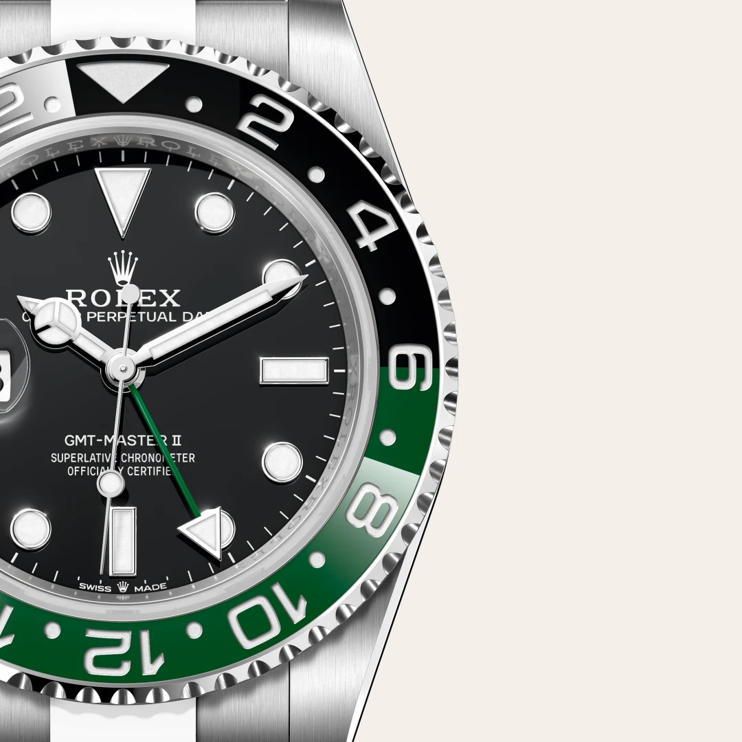 m126720vtnr-0001-slide3 | Brela Close-up of a Rolex GMT-Master II with a black dial, silver markers, and a two-tone black-and-green bezel, highlighting the watch hands and crown cup. | Brela