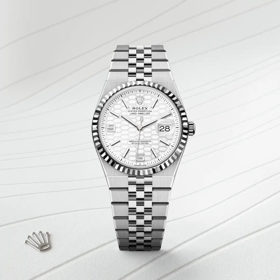 m127234-0001-slide1 | Brela Silver Rolex wristwatch with a fluted bezel, white patterned dial, and date window at 3 o'clock, stainless steel Jubilee bracelet, Rolex crown logo visible | Brela