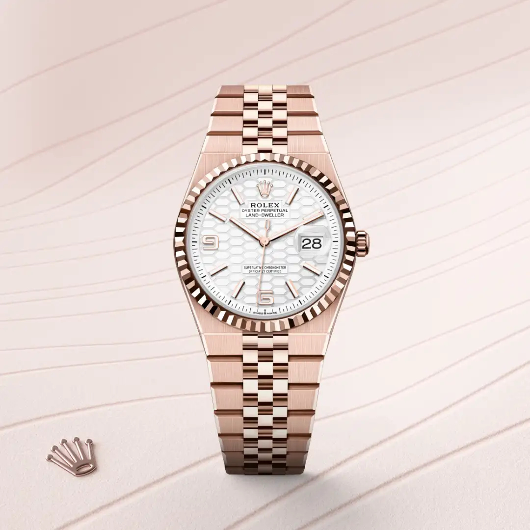 m127235-0001-slide1 | Brela Rose gold Rolex watch with a white patterned dial and date window, displaying 28 at 3 o'clock. | Brela