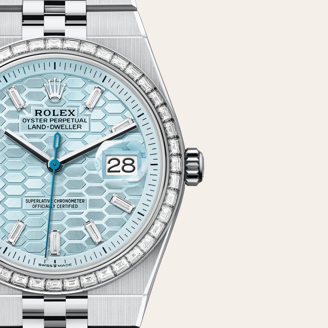 m127286tbr-0001-slide3 | Brela Close-up of a Rolex Oyster Perpetual Land-Dweller with a sky-blue honeycomb dial, diamond bezel, date at 3 o'clock, and stainless bracelet. | Brela