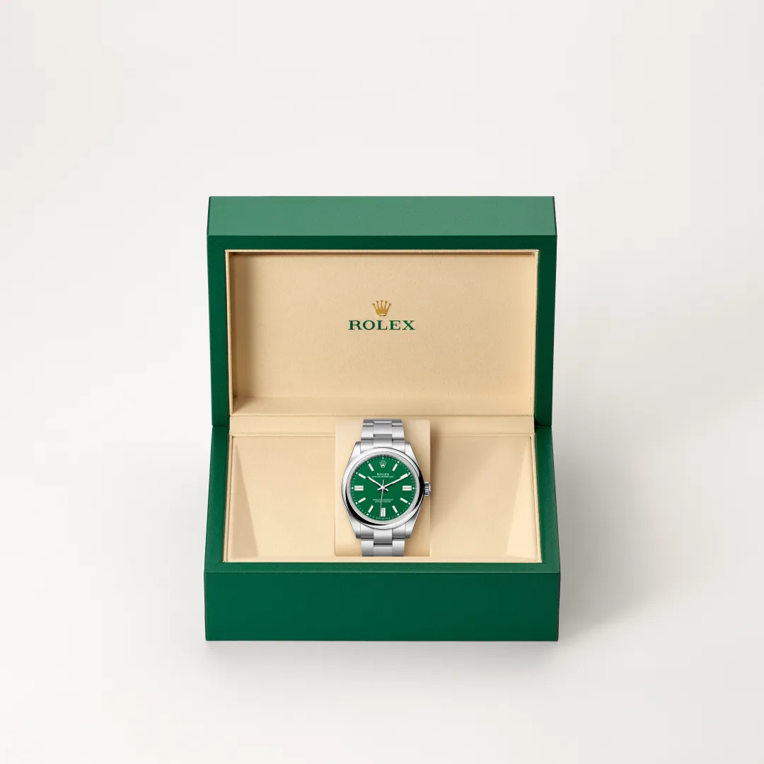 m134300-0004-slide2 | Brela Rolex watch with a green dial inside an open green box with beige interior. The brand name is visible on the lid interior. | Brela
