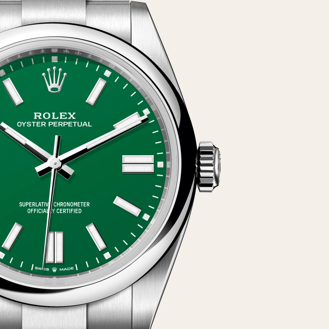 m134300-0004-slide3 | Brela Close-up of a Rolex Oyster Perpetual watch with a green dial, silver hour markers, and stainless steel bracelet and bezel | Brela
