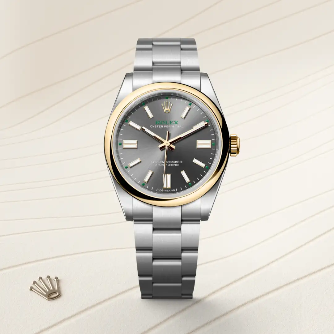 m134303-0001-slide1 | Brela Rolex Oyster Perpetual watch with two-tone gold bezel and stainless steel bracelet on a light striped background, crown logo visible on dial | Brela