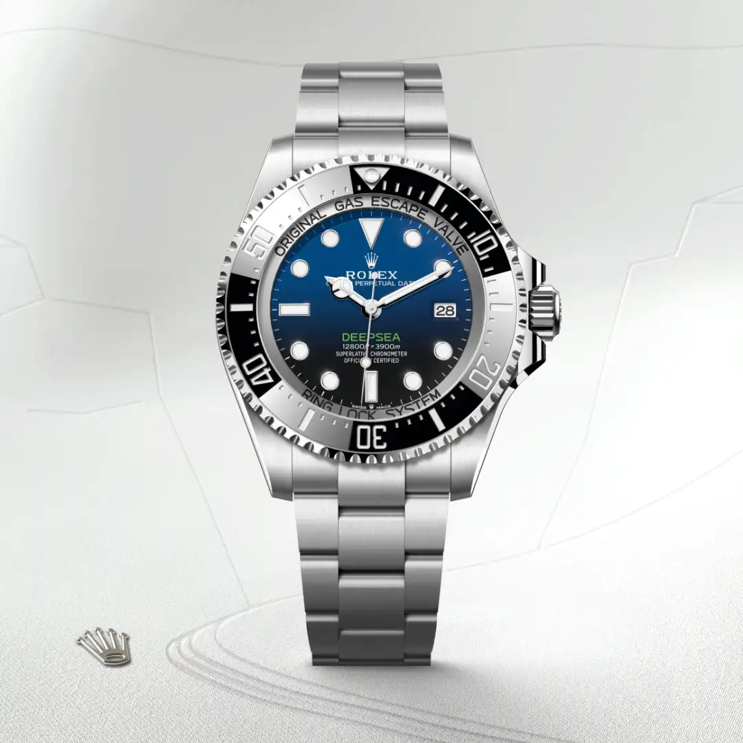 m136660-0005-slide1 | Brela Rolex Deepsea stainless steel watch with blue dial and date window at 3 o'clock, shown on a light background. | Brela