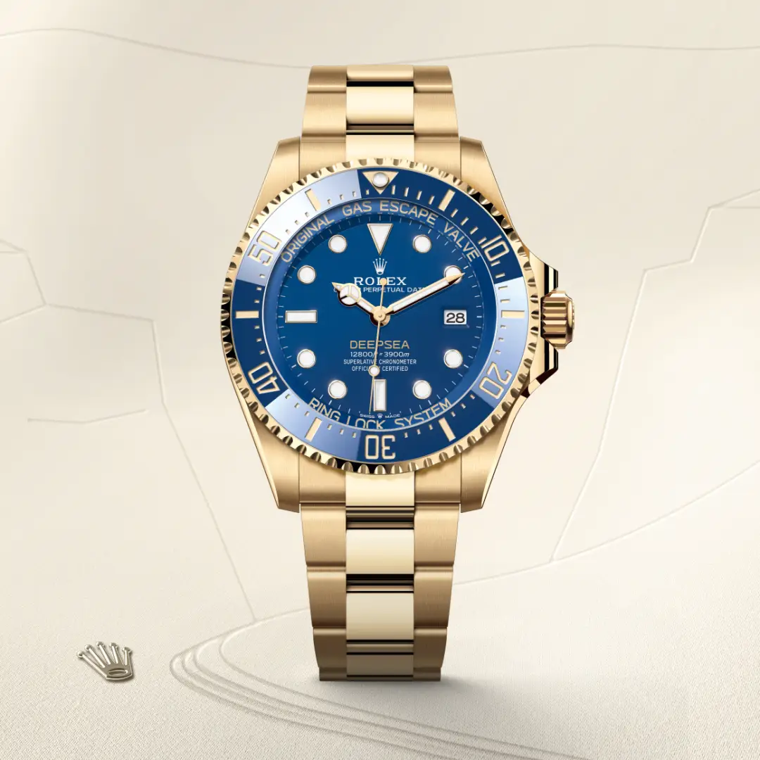 m136668lb-0001-slide1 | Brela Gold Rolex Deepsea dive watch with blue dial and date, displayed upright on a light beige background. | Brela