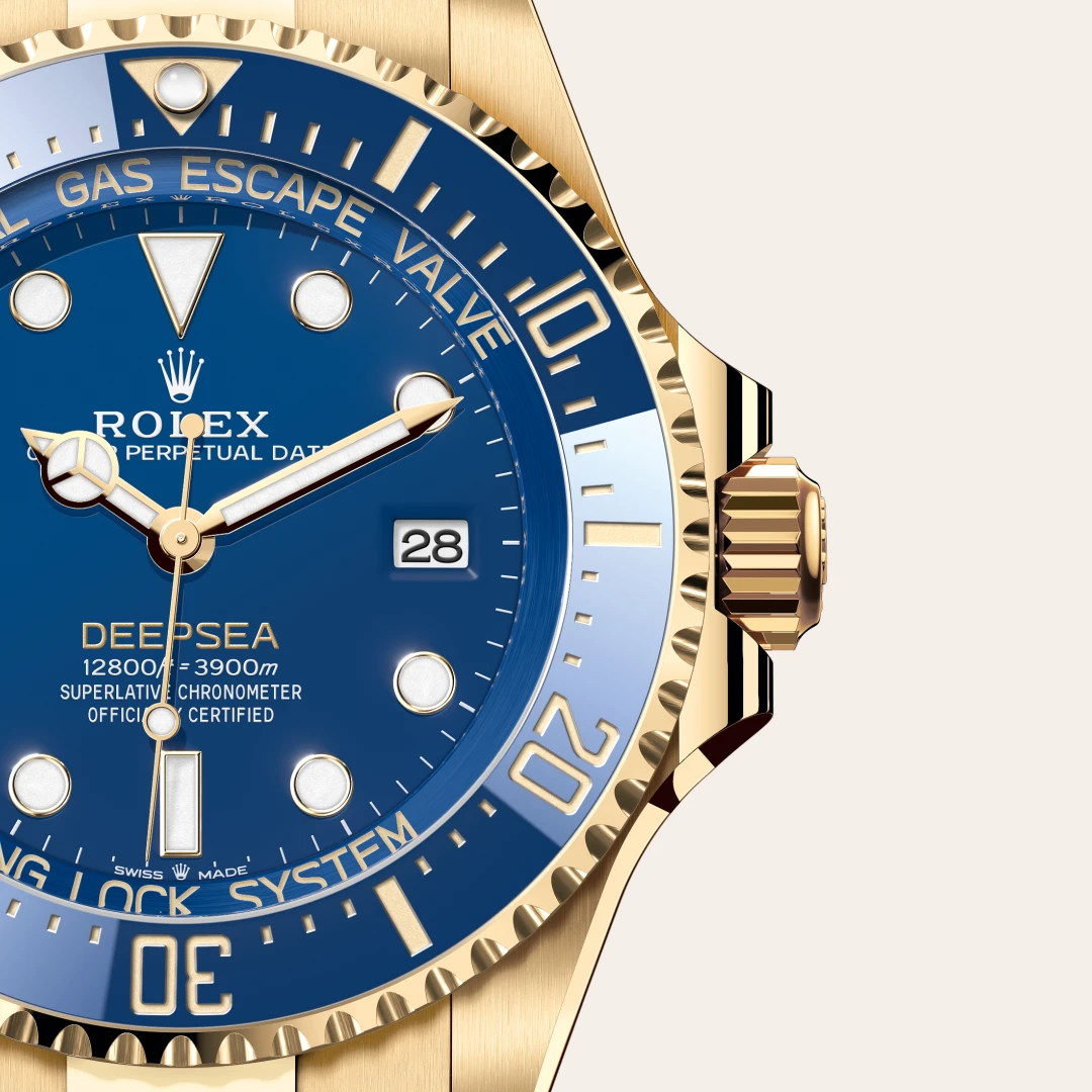m136668lb-0001-slide3 | Brela Gold Rolex Deepsea watch with blue dial and date window showing 28, close-up detail of bezel and crown | Brela