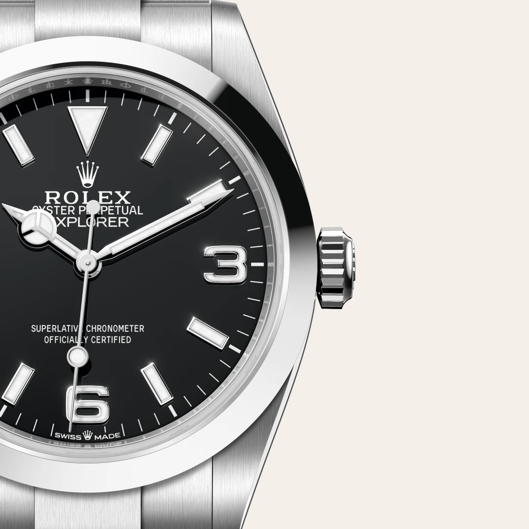 m224270-0001-slide3 | Brela Close-up of a stainless steel Rolex Explorer watch dial, showing the black face, silver hands, and large 3 and 6 numerals with crown logo and 'ROLEX' branding. | Brela
