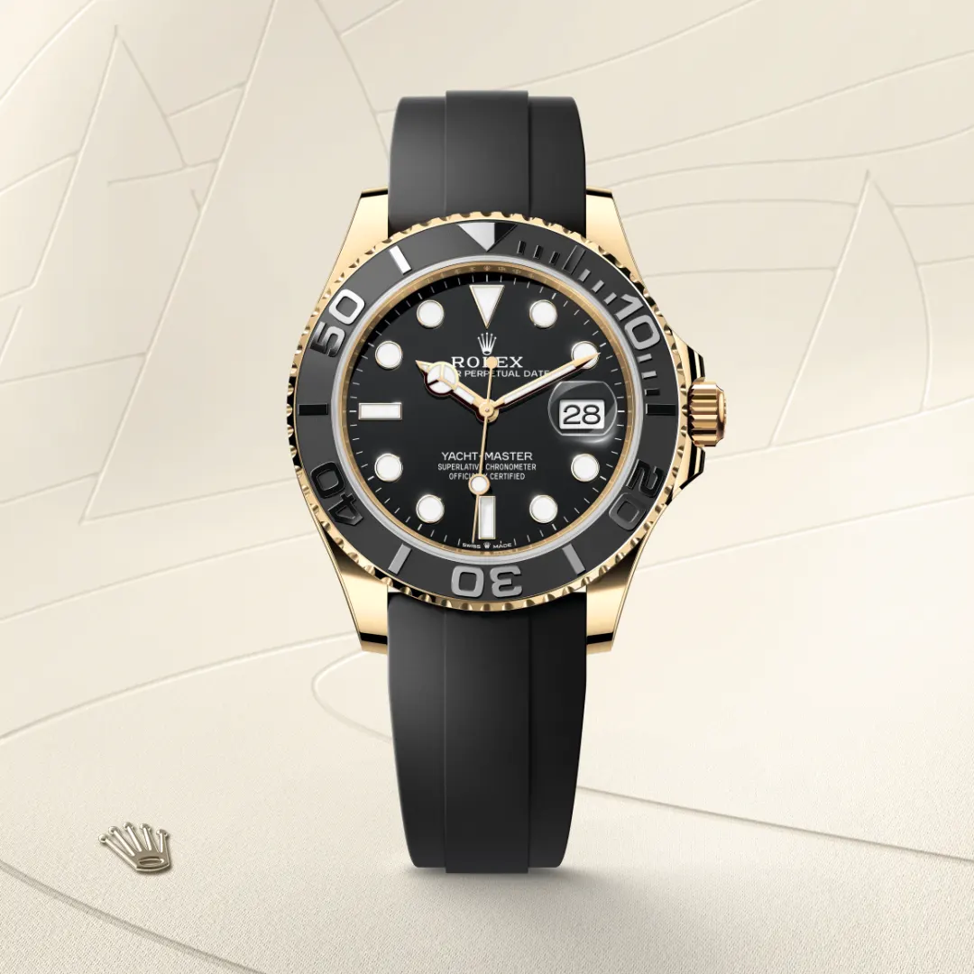 m226658-0001-slide1 | Brela Rolex Yacht-Master watch with black dial, gold case, and black rubber strap on a beige backdrop | Brela