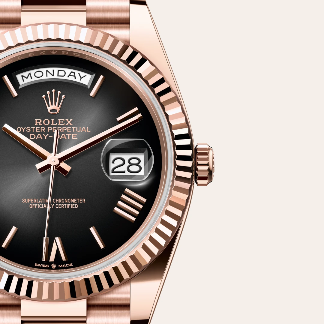 m228235-0055-slide3 | Brela Rose-gold Rolex Day-Date watch close-up: black dial, day window showing MONDAY, date window showing 28, fluted bezel. | Brela