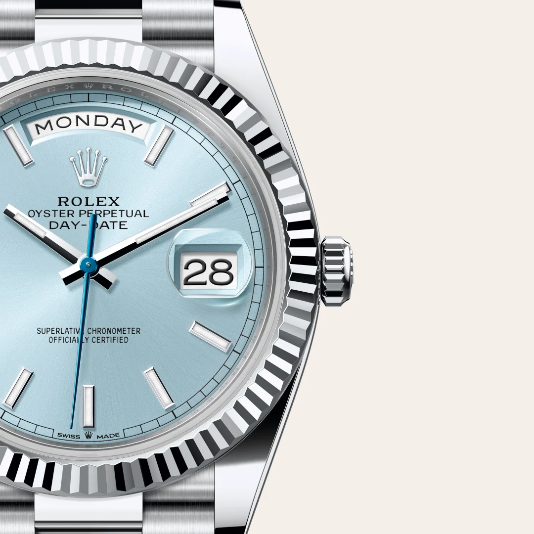Close-up of a Rolex Oyster Perpetual Day-Date wristwatch with a light blue dial, day display reading MONDAY, date window showing 28, and a silver fluted bezel. | Brela