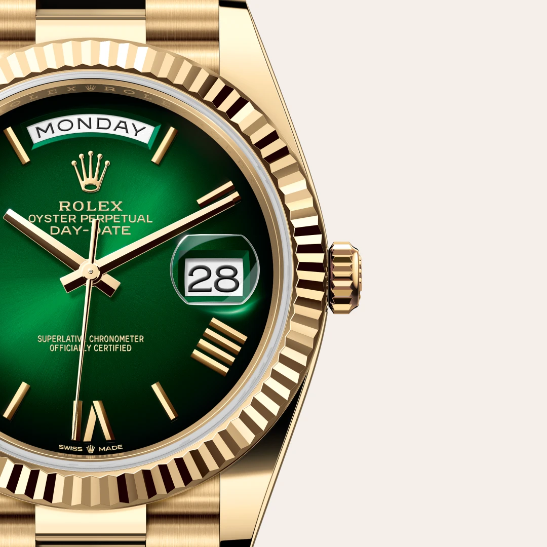 Gold Rolex Day-Date watch with a green dial, displaying Monday and the date 28, featuring a fluted bezel. | Brela