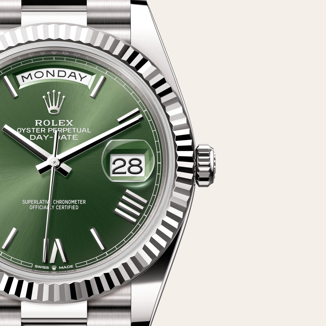 m228239-0033-slide3 | Brela Close-up of a green Rolex Day-Date watch showing the Monday day window and the date 28 with a fluted bezel and silver bracelet. | Brela