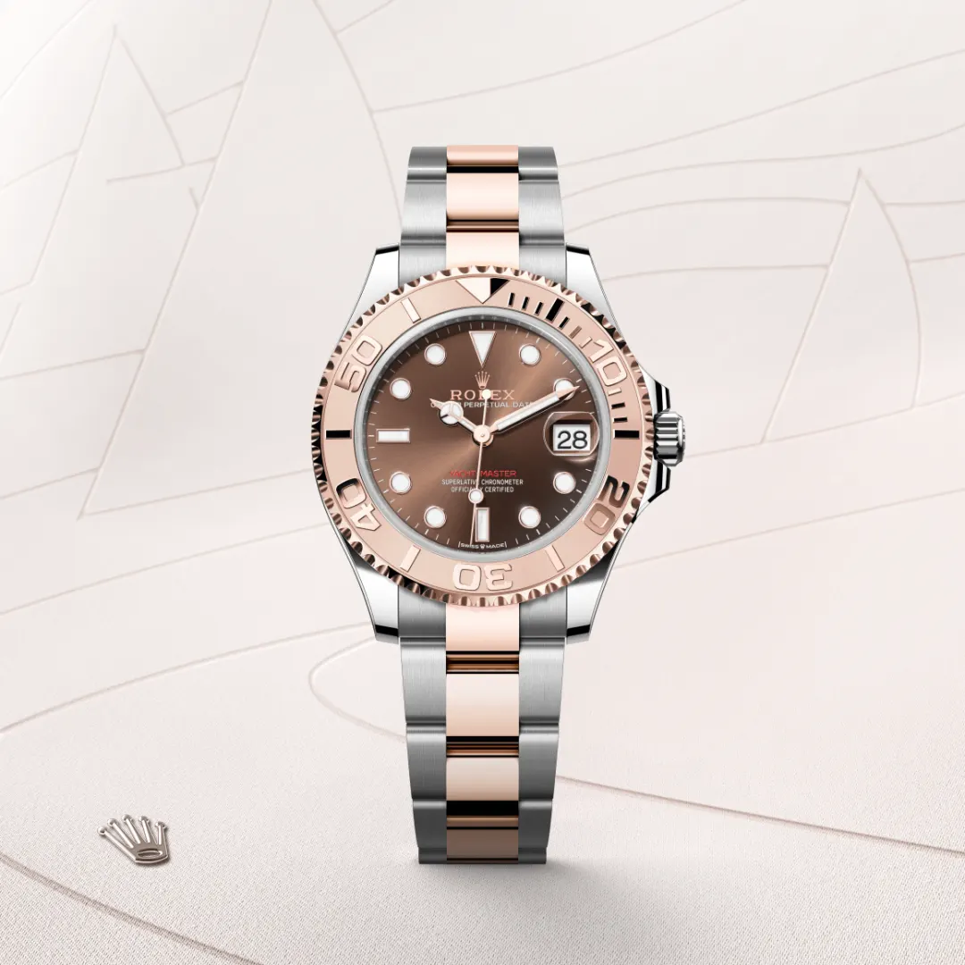 Two-tone Rolex Yacht-Master watch with rose gold bezel and center links, brown dial, date at 3, set against a light beige backdrop. | Brela