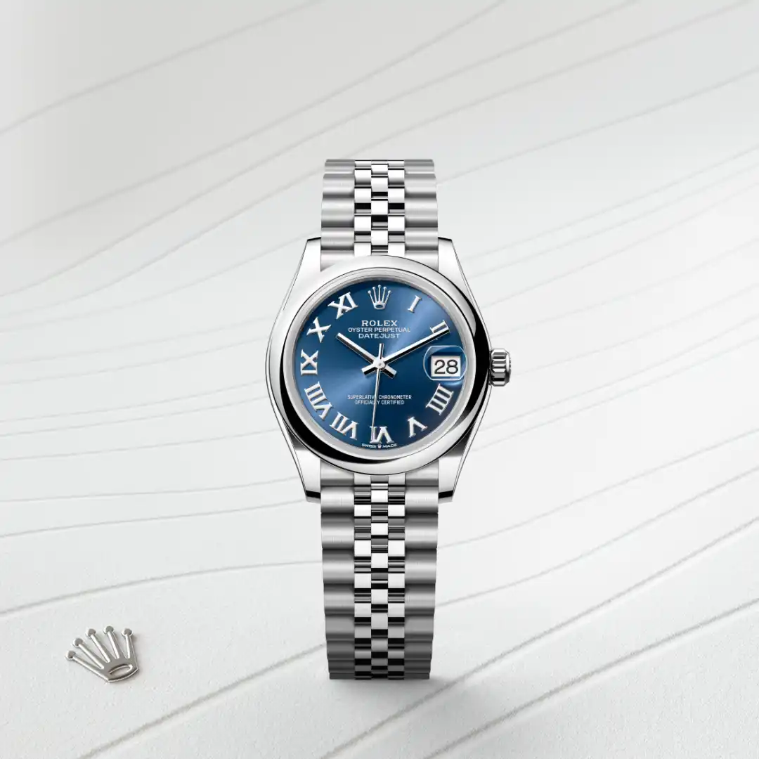 Rolex Datejust wristwatch with a blue dial, white Roman numerals, date window at 3 o'clock, and a stainless steel Jubilee bracelet on a light background with the Rolex crown emblem nearby. | Brela
