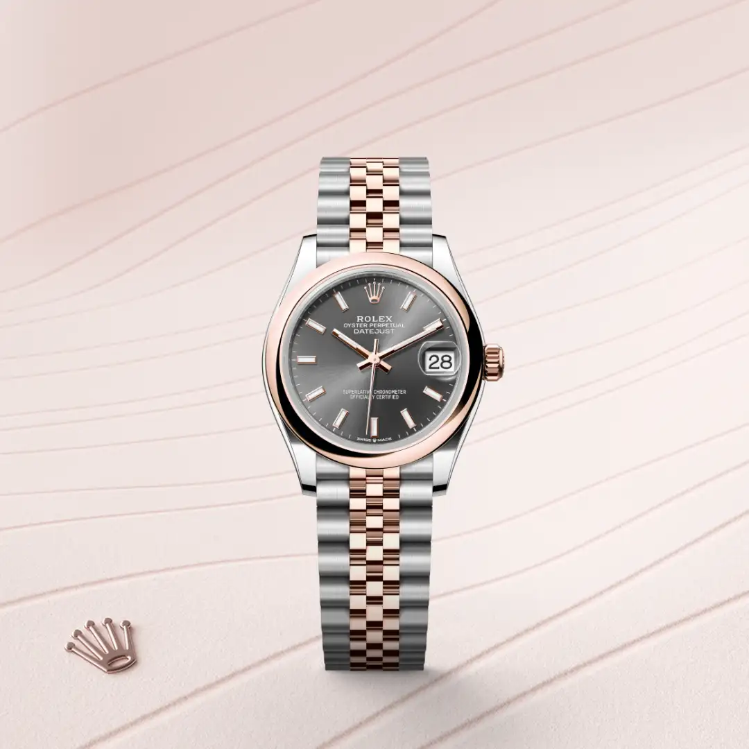 Two-tone Rolex Datejust wristwatch with gray dial, rose gold bezel, and Jubilee bracelet on a pale pink background, displaying date 28. | Brela