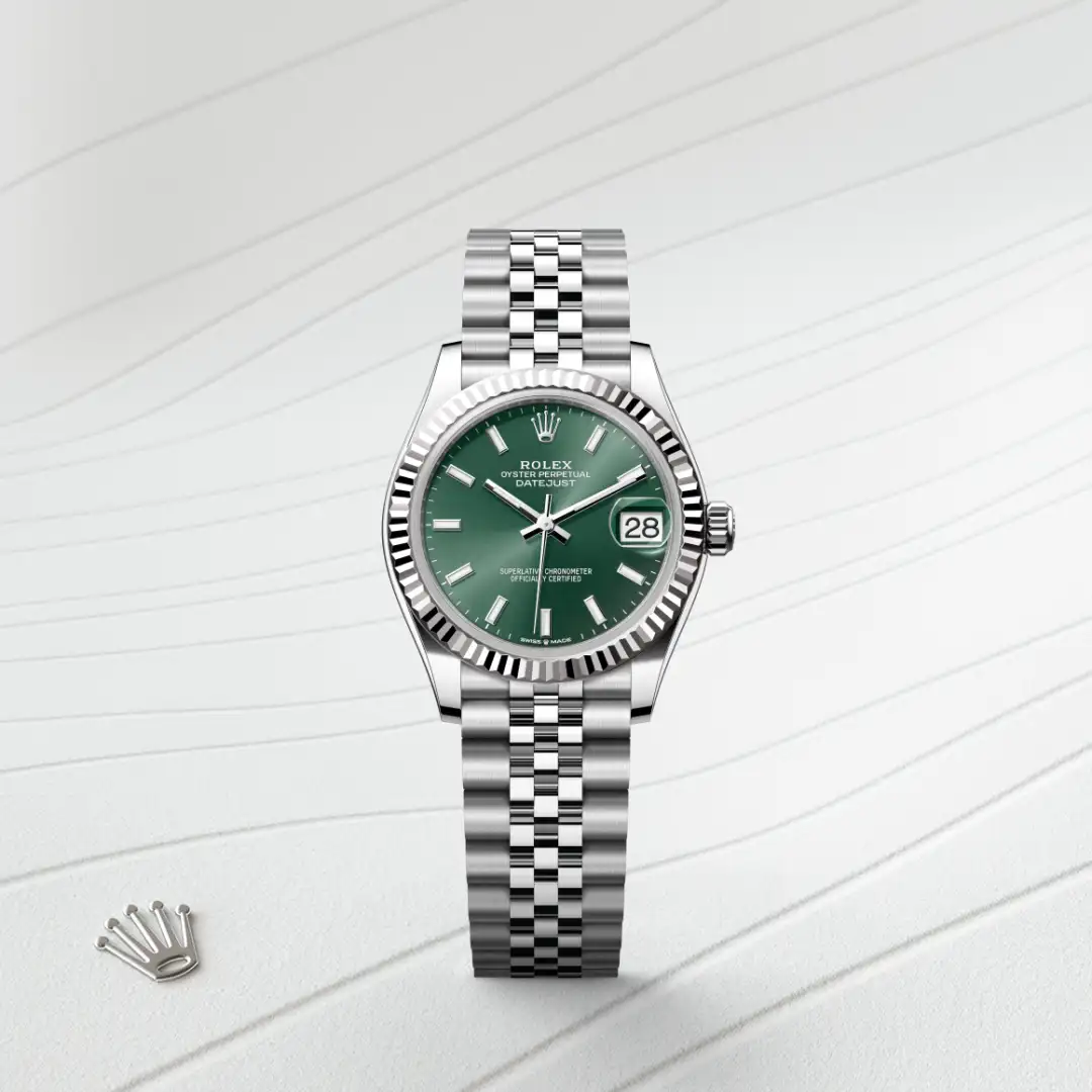 Rolex Datejust watch with a green dial, fluted bezel, and silver Jubilee bracelet with date at 3 o'clock on a light background. | Brela