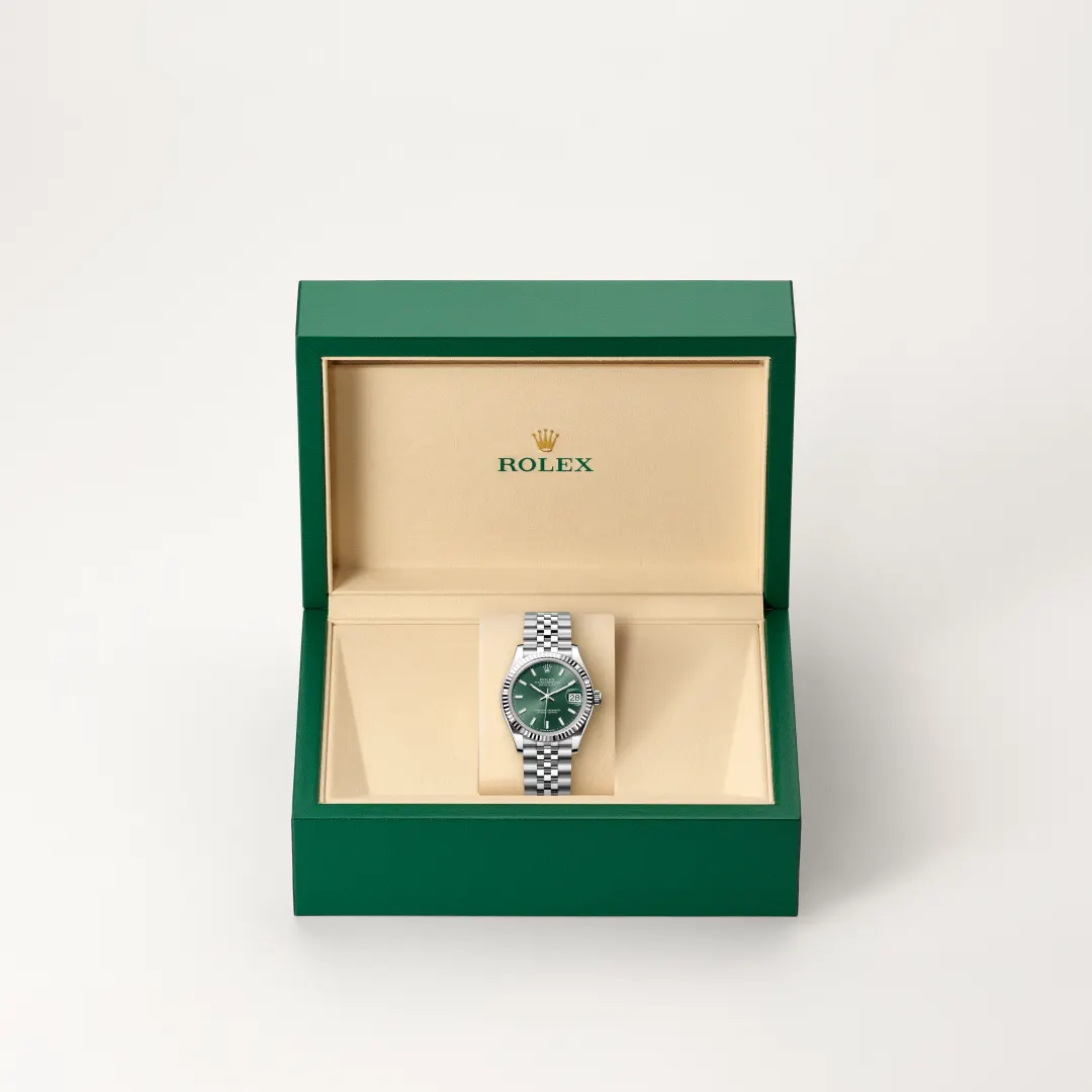 Open green Rolex presentation box revealing a stainless steel Rolex watch with green dial on a beige interior. | Brela