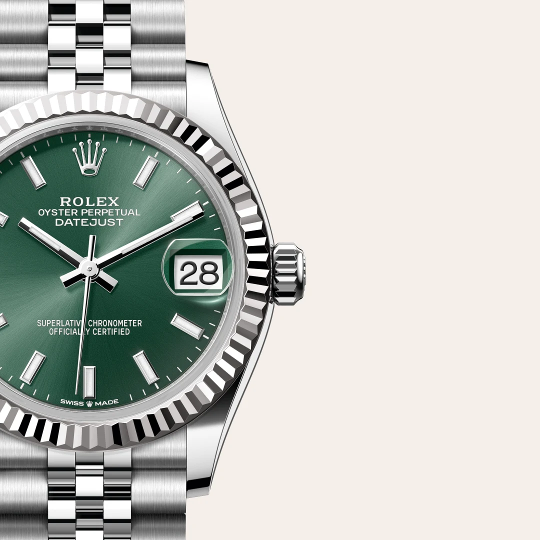 Close-up of a Rolex Oyster Perpetual Datejust watch with a green dial, date window showing 28, fluted bezel and stainless steel Jubilee bracelet. | Brela