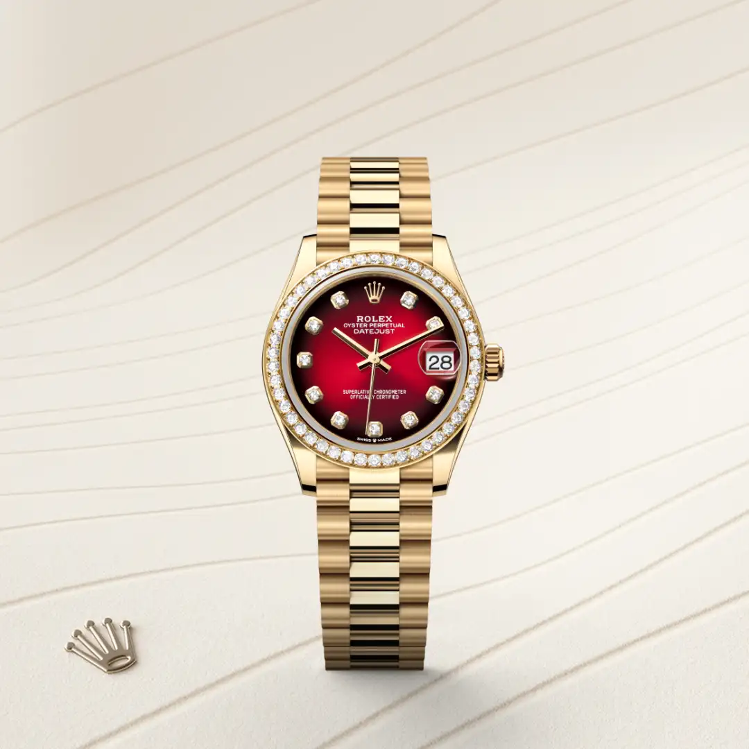 Gold Rolex Datejust wristwatch with a diamond-studded bezel, red dial, and date window showing 28 on a cream background. | Brela